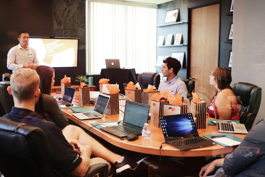 A trainer leading a hands-on session with a group at laptops